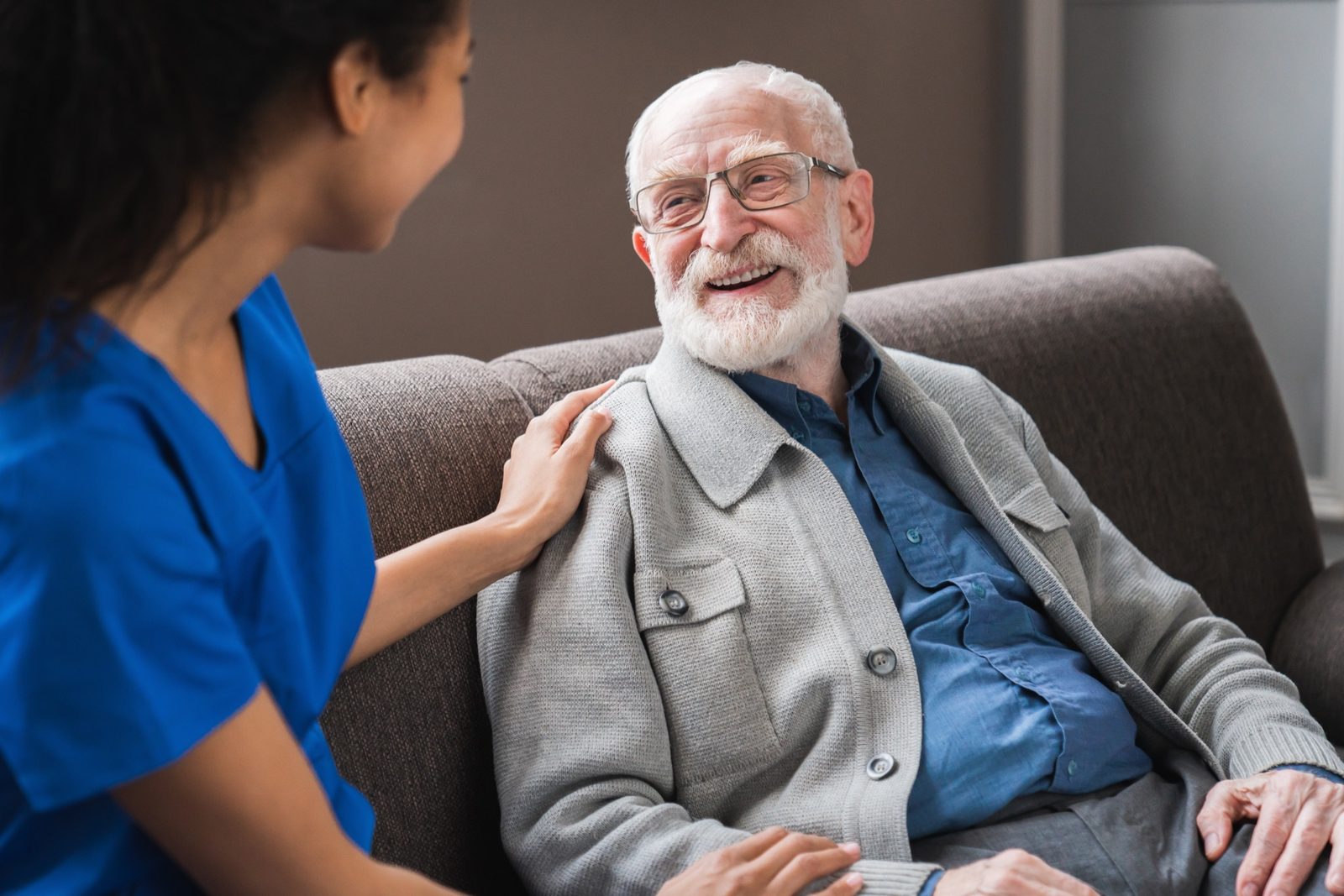 Member laughing with a visiting nurse at home